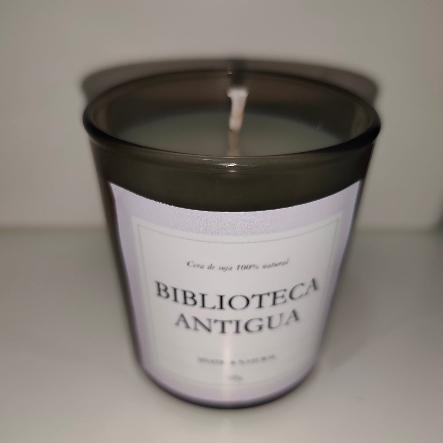 vela de cera de soja con aroma a biblioteca antigua en vaso negro transparente de cristal hecho a mano ene spaña por mistica y natural