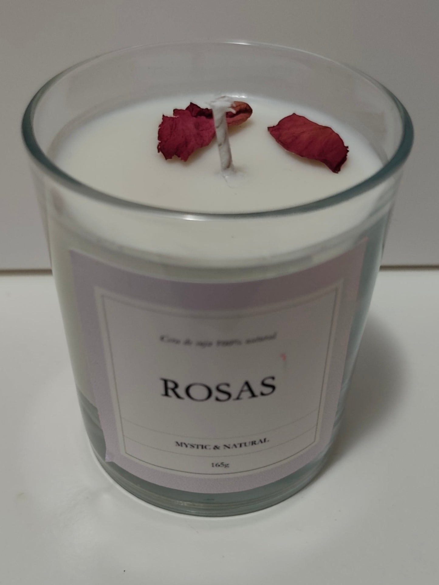vela de cera de soja natural con aroma a rosas en vaso de  vidrio transparente de color blanco y con petalos decorativos hecho a mano en españa por mistica y natural wax